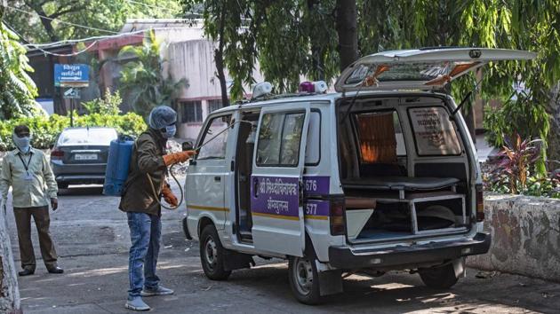 The ambulance that brought the Covid-19 positive victim sanitised by staff at Vaikunth crematorium in Pune on Monday.(PRATHAM GOKHALE/HT)