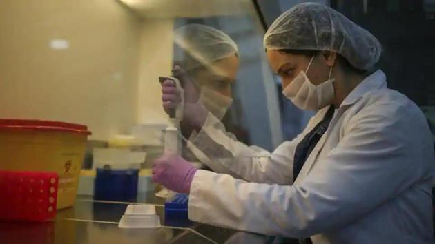 Wearing a protective suit, a research and development company employee works on the production of coronavirus testing kits in Gebze, northwestern Turkey.(AP File Photo)