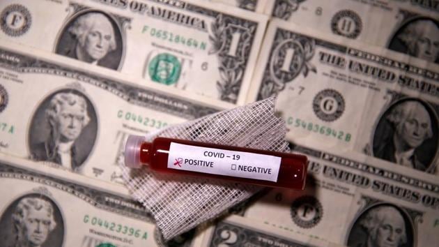 Test tube with fake blood labelled with the coronavirus disease (COVID-19) is placed on dollar banknotes in this illustration taken March 27, 2020.(REUTERS) Test tube with fake blood labelled with the coronavirus disease (COVID-19) is placed on dollar banknotes in this illustration taken March 27, 2020.(REUTERS)