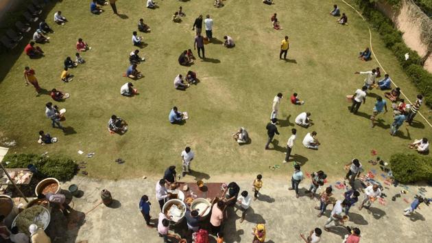 Migrant workers and homeless people practice social distancing while eating their meal in a community ground at Khandsa Village near Hero Honda Chowk in Gurugram. (Parveen Kumar / HT Photo) Migrant workers and homeless people practice social distancing while eating their meal in a community ground at Khandsa Village near Hero Honda Chowk in Gurugram. (Parveen Kumar / HT Photo)