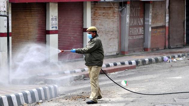A fire services personnel sprays disinfectant during sanitization of the Gujjar Nagar area on day 7 of the 21-day nationwide lockdown to check the spread of coronavirus in Jammu, Jammu and Kashmir on Tuesday.(Nitin Kanotra/HT Photo)