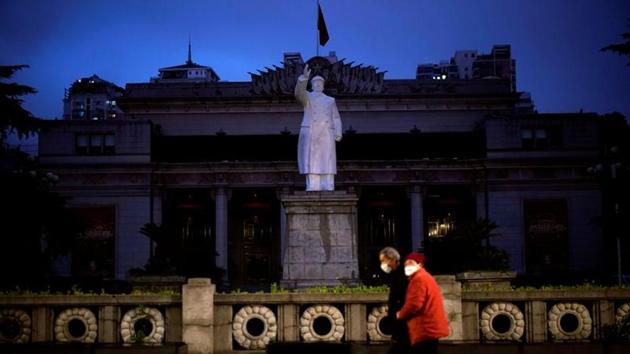 A couple wearing face masks walk past a statue of former leader Mao Zedong. Wuhan suffered 2,547 coronavirus deaths, accounting for about 80% of China’s total fatality toll of 3,186 as of Sunday, according to the National Health Commission. (Aly Song / REUTERS)