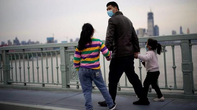 People wearing face masks walk on a bridge. With the United States, Italy and Spain and other countries now battling soaring infections, China is focusing on the risk posed by imported cases - most of them Chinese returning home. Effective Saturday, China suspended the entry of foreign nationals with valid Chinese visas and residence permits. (Aly Song / REUTERS)