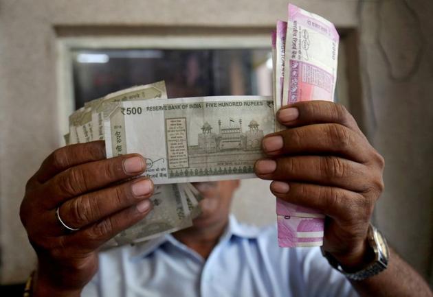 A cashier checks Indian rupee notes inside a room at a fuel station in Ahmedabad, India. (REUTERS) A cashier checks Indian rupee notes inside a room at a fuel station in Ahmedabad, India. (REUTERS)