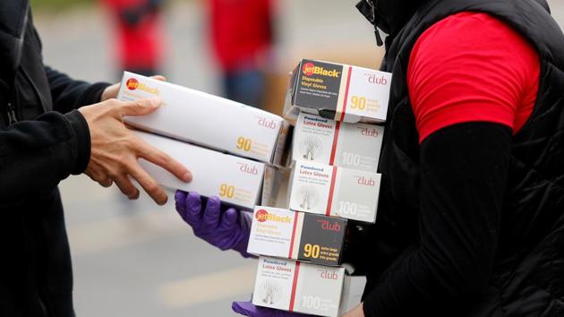 Volunteers with Project C.U.R.E. accept personal protective equipment (PPE) from a motorist to be donated to healthcare workers treating coronavirus disease (COVID-19) in Chicago, Illinois, US.(REUTERS)