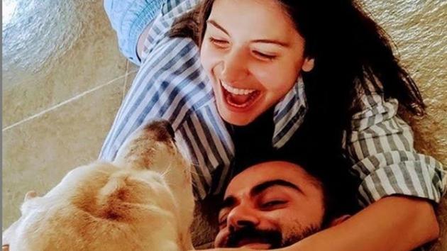 Anushka Sharma and Virat Kohli with their dog.