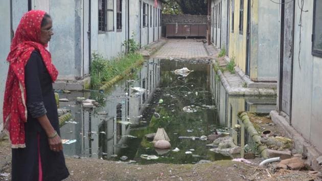 A woman walking past a swamp of stagnant sewage at rag pickers’ colony in Sector 56, Chandigarh, on Tuesday.(HT PHOTO)