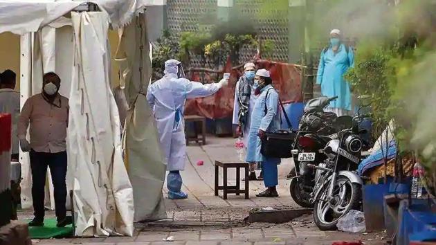 A volunteer wearing protective suit checks temperature of a man at Nizamuddin during coronavirus lockdown in New Delhi. (ANI) A volunteer wearing protective suit checks temperature of a man at Nizamuddin during coronavirus lockdown in New Delhi. (ANI)