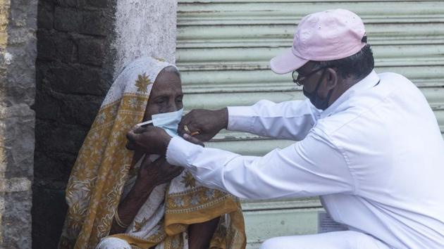 A health department personnel helps an elderly woman to wear a mask at Islampur near Sangli, on Tuesday. (Pratham Gokhale/HT Photo) A health department personnel helps an elderly woman to wear a mask at Islampur near Sangli, on Tuesday. (Pratham Gokhale/HT Photo)