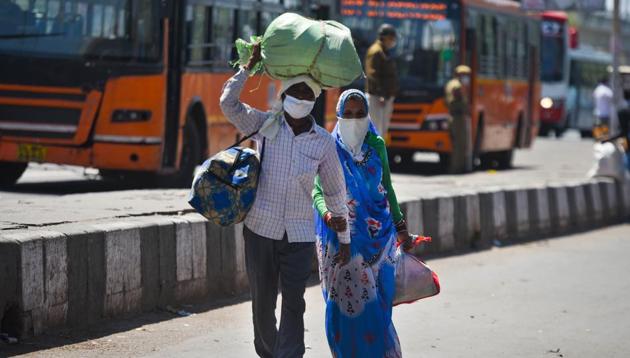 Migrant workers head home on Day 5 of the 21 day nationwide lockdown imposed by PM Narendra Modi to curb the spread of coronavirus, outside Anand Vihar Bus Terminus, in New Delhi, India, on Sunday, March 29, 2020.(Amal KS/HT PHOTO)