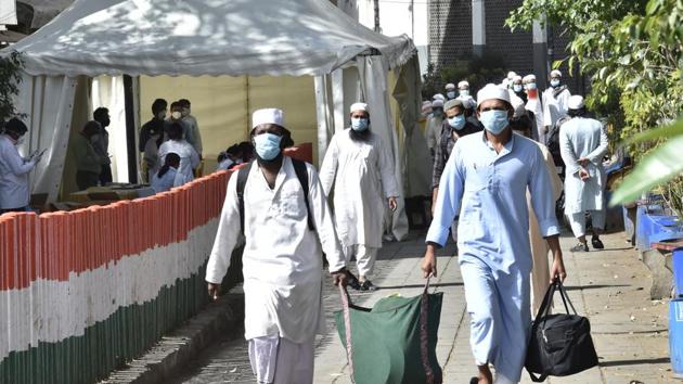 People who took part in a Tablighi Jamaat function earlier this month walk to board buses that will take them to a quarantine facility amid concerns of infection, on day 7 of the 21 day nationwide at Nizamuddin West in New Delhi on, March 31, 2020.(Ajay Aggarwal/HT Photo)