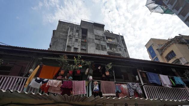 Rashami Ramesh Paradkar, Vrushali Shetkar-- both housewives, and Aniket Panchal, a teacher, look out from a common balcony in their chawl in Mumbai. Pollution in India’s metros has seen a sharp reduction over the last week, if only at the cost of its people indoors, roads empty, factories and construction activity at a standstill. (Hemanshi Kamani / REUTERS)