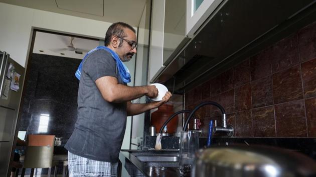 Hitesh Mehta washes tableware inside the kitchen of his three-room apartment in Mumbai. The days indoors have also meant picking up on tasks on hold, trying out new hobbies, helping out or simply reflection. (Hemanshi Kamani / REUTERS)