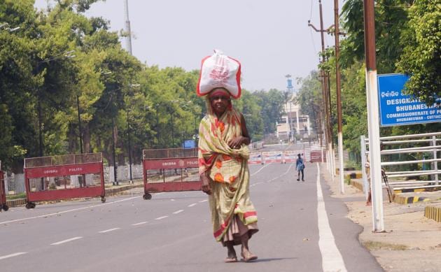 An elderly woman carry belongings on her head as she walk past the Odisha assembly inBhubaneswar during the lockdown to contain the spread of COVID-19, March 25, 2020.(ANI File / Representational Photo)