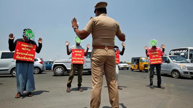 People in masks depicting the coronavirus and placards that read: “Don’t come out, don’t go near corona” provided by police as a punishment for breaking a lockdown imposed to slow the coronavirus disease (COVID-19) in Chennai, on April 1, 2020. This is one of many offbeat measures the police have taken towards offenders of a lockdown for our collective health instead of a law and order issue. (P. Ravikumar / REUTERS)