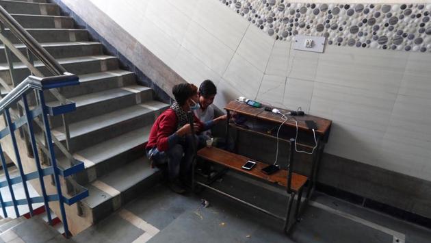 Migrant workers charge their phones at a government-run temporary shelter in a school, during the 21-day nationwide lockdown in New Delhi, India, March 31, 2020. A large number of the migrant workers who had been walking on foot after the lockdown began have since been put up in shelter homes or been provided further transport by state governments. (Adnan Abidi / REUTERS)