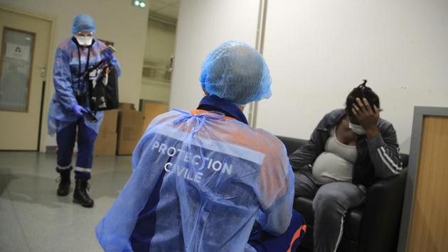 Vincent Jactel, a member of the Civil Protection service, talks with a 27-year-old pregnant woman suspected of being infected with the virus in a social housing building. (Michel Euler / AP) Vincent Jactel, a member of the Civil Protection service, talks with a 27-year-old pregnant woman suspected of being infected with the virus in a social housing building. (Michel Euler / AP)