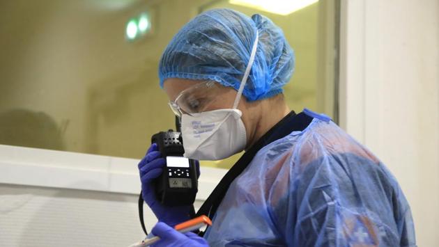 Aurore Lejeune, who builds bridges for the SNCF rail authority in her other life, checks a thermometer as she talks to a doctor on a walkie-talkie. Lejeune is in her 14th year volunteering for Civil Protection, but she says she hasn't encountered such high-risk situations in the past. “We’re facing a very contagious virus ... so we have to learn fast.” (Michel Euler / AP) Aurore Lejeune, who builds bridges for the SNCF rail authority in her other life, checks a thermometer as she talks to a doctor on a walkie-talkie. Lejeune is in her 14th year volunteering for Civil Protection, but she says she hasn't encountered such high-risk situations in the past. “We’re facing a very contagious virus ... so we have to learn fast.” (Michel Euler / AP)