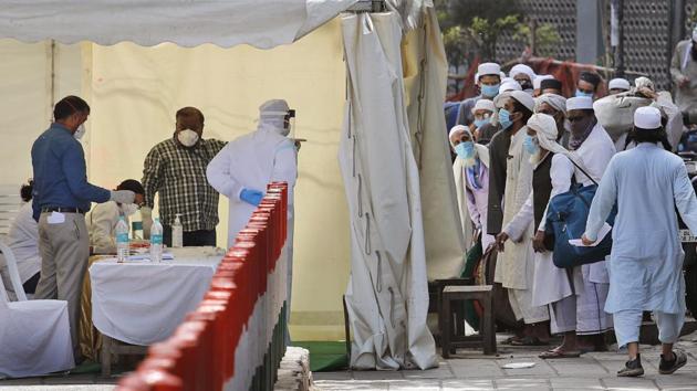 Paramedics note down names of Muslims pilgrims before they are taken to a quarantine facility, amid concerns over the spread of the new coronavirus, at the Nizamuddin area of New Delhi, on March 31. (AP Photo) Paramedics note down names of Muslims pilgrims before they are taken to a quarantine facility, amid concerns over the spread of the new coronavirus, at the Nizamuddin area of New Delhi, on March 31. (AP Photo)