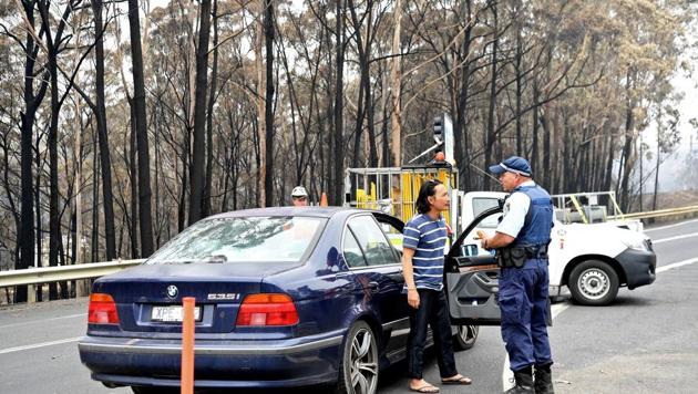 Police issue an infringement notice to a man who refused to stop at a road block in Kiah, Australia. (REUTERS) Police issue an infringement notice to a man who refused to stop at a road block in Kiah, Australia. (REUTERS)