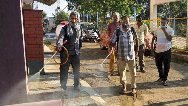 Municipal workers spray disinfectants in a drain at a residential area in the wake of coronavirus pandemic, in Karnataka’s Chikmagalur, on April 1.(PTI Photo)