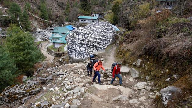 Trekkers and their guide making their way along a path in Phakding. The shutdown cost at least four million dollars in lost revenue from climbing permits. An Everest permit alone costs $11,000. But Sherpa and other guides, who are often the sole breadwinners for their families, say they face a more desperate problem. The Everest season from early April to the end of May feeds his family for the whole year. (Prakash Mathema / AFP)