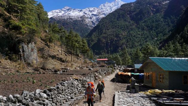 Trekkers make their way along a path in the Mt. Everest region, Nepal. While there are no reported cases in the Himalayan town of Khumjung -- home to many of the ethnic Sherpas who dominate the industry helping climbers, the Himalayas have been closed by the global shutdown of borders and air travel. (Prakash Mathema / AFP)