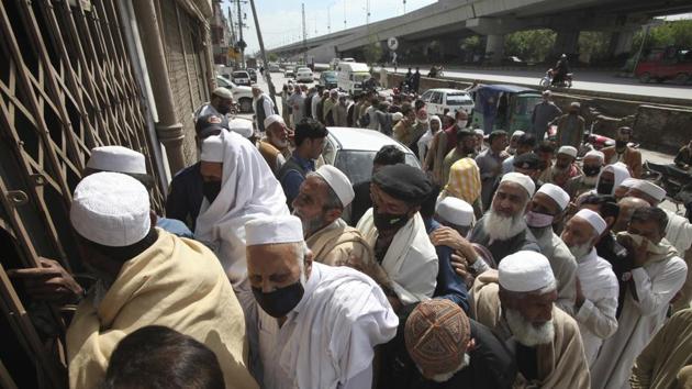 Pakistani government employees gather outside a bank to receive their salaries, ignoring social distancing recommendations to help avoid the spread of coronavirus, in Peshawar on April 1. (AP Photo) Pakistani government employees gather outside a bank to receive their salaries, ignoring social distancing recommendations to help avoid the spread of coronavirus, in Peshawar on April 1. (AP Photo)