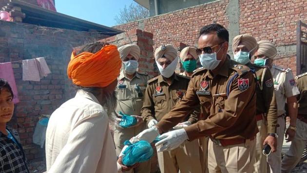 Former Indian hockey team forward Gagan Ajit Singh hands out food parcel to the poor in Amritsar. Singh is currently a DCP with Punjab Police.(Hindustan Times/Special Arrangement)