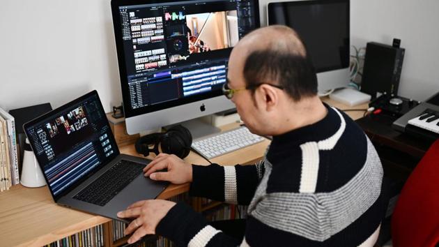 The mastermind of the teleworking orchestra, trombonist Hisato Yamaguchi, 45, edits videos of his fellow colleagues playing music at home in Tokyo. “An orchestra like ours creates music together within a group of 80 musicians. Having to stay alone and not be able to come together to play is the most unbearable thing,” he said. (Charly Triballeau / AFP) The mastermind of the teleworking orchestra, trombonist Hisato Yamaguchi, 45, edits videos of his fellow colleagues playing music at home in Tokyo. “An orchestra like ours creates music together within a group of 80 musicians. Having to stay alone and not be able to come together to play is the most unbearable thing,” he said. (Charly Triballeau / AFP)