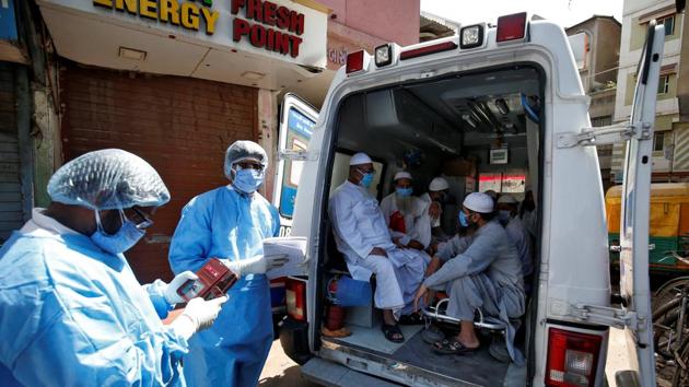 Men, who according to health and police officials had visited three Muslim missionary gatherings including in Nizamuddin area of New Delhi, wearing protective masks sit in an ambulance that will take them to a quarantine facility amid concerns about the spread of coronavirus disease (COVID-19), in Ahmedabad.(REUTERS)