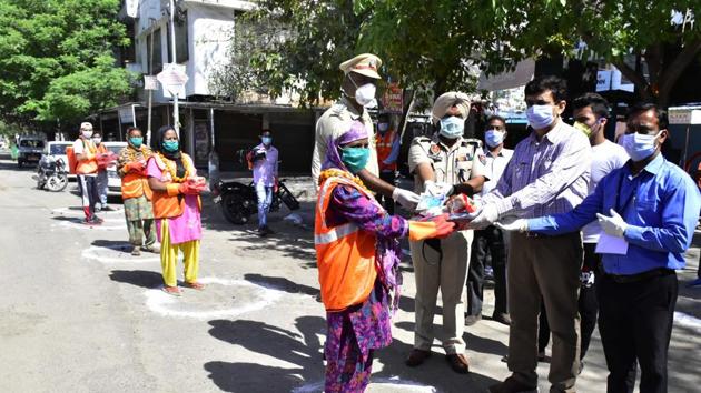 Amritsar, India - April 03, 2020: Punjab Police personnel with Municipal Corporation employees present new kits to the cleaning staff on day ten of the 21 day nationwide lockdown to curb the spread of coronavirus, at Mahan Singh Gate, in Amritsar, Punjab, India, on Friday, April 03, 2020. (Photo by Sameer Sehgal / Hindustan Times) Amritsar, India - April 03, 2020: Punjab Police personnel with Municipal Corporation employees present new kits to the cleaning staff on day ten of the 21 day nationwide lockdown to curb the spread of coronavirus, at Mahan Singh Gate, in Amritsar, Punjab, India, on Friday, April 03, 2020. (Photo by Sameer Sehgal / Hindustan Times)