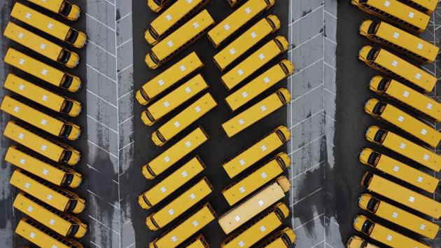 School buses sit parked in a lot as schools remain closed due to the coronavirus in Providence, Rhode Island. (David Goldman / AP) School buses sit parked in a lot as schools remain closed due to the coronavirus in Providence, Rhode Island. (David Goldman / AP)