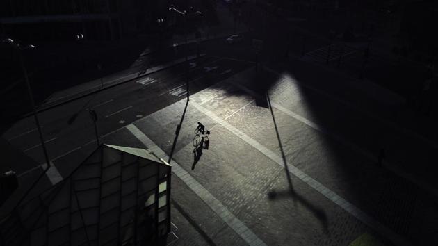 A lone bicyclist peddles though an empty Dewey Square Plaza outside South Station at rush hour, which would normally be bustling with people catching trains home in Boston. (David Goldman / AP) A lone bicyclist peddles though an empty Dewey Square Plaza outside South Station at rush hour, which would normally be bustling with people catching trains home in Boston. (David Goldman / AP)