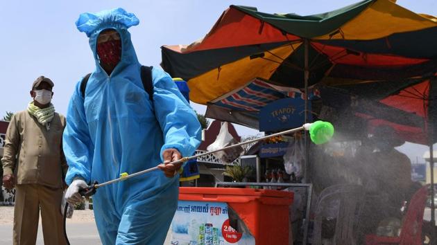 A worker wearing a protective suit sprays disinfectant on a street as a preventive measure against the spread of the COVID-19 coronavirus(AFP)