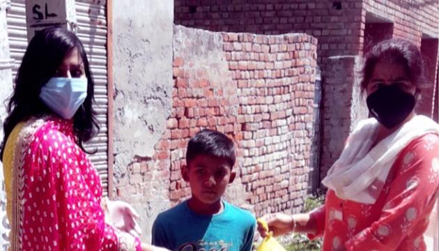 Teachers handing over food packets to a schoolchild in Rohtak's Kalanaur on Sunday. (Manoj Dhaka/HT) Teachers handing over food packets to a schoolchild in Rohtak's Kalanaur on Sunday. (Manoj Dhaka/HT)