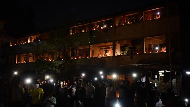 Residents of Sane Guruji Wasahat light candles, diyas and mobile torch lights in a show of solidarity for India’s battle against the coronavirus on Sunday night. (Milind Saurkar / HT Photo) 