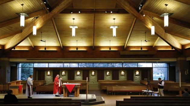 The Rev. Michael Amadeo celebrates Mass during the broadcast and recording of the Palm Sunday Mass at a church in Iowa on Saturday. (AP Photo) The Rev. Michael Amadeo celebrates Mass during the broadcast and recording of the Palm Sunday Mass at a church in Iowa on Saturday. (AP Photo)