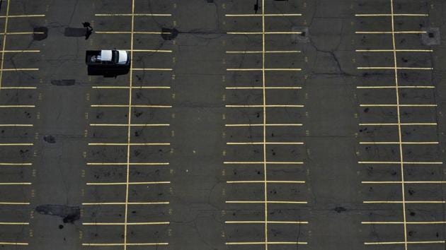 A driver walks to catch the train toward Boston after parking in the unusually empty lot for commuters in South Attleboro. The patterns of daily routines in self-isolation are mirrored by the patterns of empty parking lots --distanced and confined for the sake of social order. (David Goldman / AP) A driver walks to catch the train toward Boston after parking in the unusually empty lot for commuters in South Attleboro. The patterns of daily routines in self-isolation are mirrored by the patterns of empty parking lots --distanced and confined for the sake of social order. (David Goldman / AP)