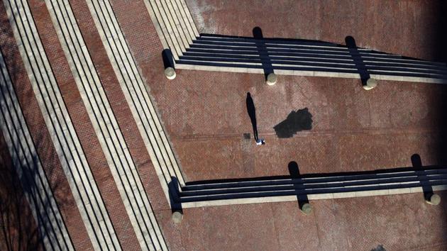 The late afternoon sun casts a long shadow of a lone pedestrian walking up the steps of City Hall Plaza, in Boston. Long shadows of solitary figures in the early spring sunshine are the few signs of human presence in spaces carved out for public use, meant for public affairs. (David Goldman / AP) The late afternoon sun casts a long shadow of a lone pedestrian walking up the steps of City Hall Plaza, in Boston. Long shadows of solitary figures in the early spring sunshine are the few signs of human presence in spaces carved out for public use, meant for public affairs. (David Goldman / AP)