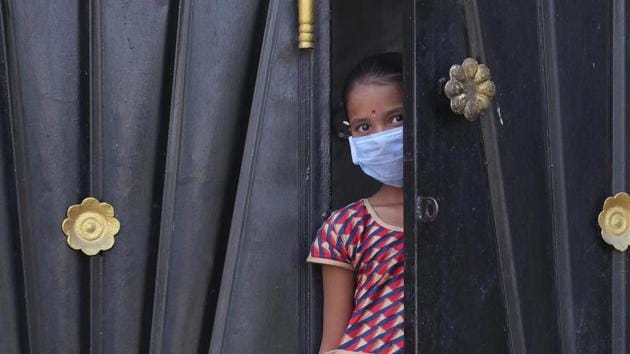 A girl looks out from the gate of her house during lockdown. (AP) A girl looks out from the gate of her house during lockdown. (AP)
