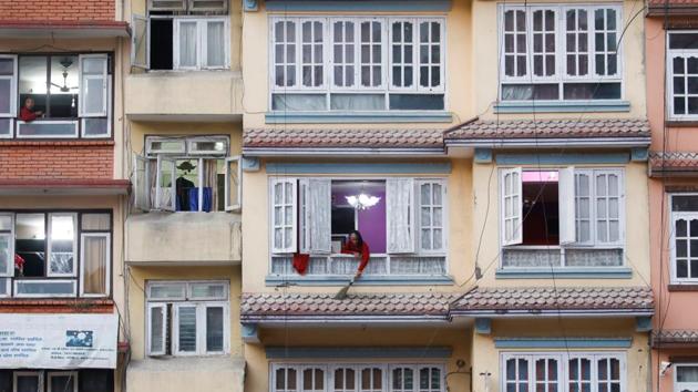 A woman cleans the terrace outside her window during the lockdown in Kathmandu, Nepal. (Navesh Chitrakar / REUTERS)