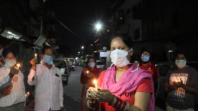 DEFEATING THE PURPOSE: Residents gathered on a street, giving two hoots to the PM’s appeal for social distancing, during the candlelight vigil against coronavirus in Mohali on Sunday.(gurminder singh/ht)