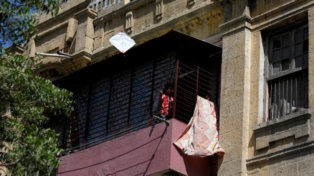A boy flies a kite from behind the grill of his family house in Karachi during a lockdown after Pakistan shut all markets, public places and discouraged large gatherings. (Akhtar Somroo / REUTERS)