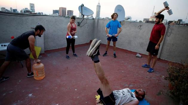 People exercise on a roof with home-made weights as the spread of COVID-19 continues in Mexico City, Mexico. (Gustavo Graf / REUTERS)