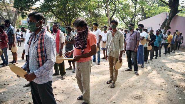 People stand in a queue to receive food at a makeshift shelter set up in a school as part of nationwide lockdown to contain the spread of coronavirus pandemic, in Vijayawada on Sunday. (ANI Photo) People stand in a queue to receive food at a makeshift shelter set up in a school as part of nationwide lockdown to contain the spread of coronavirus pandemic, in Vijayawada on Sunday. (ANI Photo)