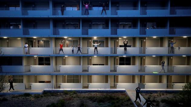 Residents exercise on their balconies following fitness trainers in Nantes while a lockdown is imposed to slow the spread of the coronavirus in France. (Stephane Mahe / REUTERS)