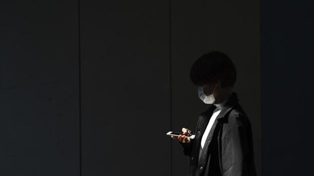 A woman with a protective face mask walks into the shade of an underpass Monday, April 6, 2020, in Tokyo. The new coronavirus causes mild or moderate symptoms for most people, but for some, especially older adults and people with existing health problems, it can cause more severe illness or death. (AP Photo/Eugene Hoshiko) (AP) A woman with a protective face mask walks into the shade of an underpass Monday, April 6, 2020, in Tokyo. The new coronavirus causes mild or moderate symptoms for most people, but for some, especially older adults and people with existing health problems, it can cause more severe illness or death. (AP Photo/Eugene Hoshiko) (AP)