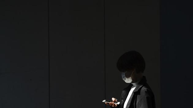 A woman with a protective face mask walks into the shade of an underpass in Tokyo. (AP) A woman with a protective face mask walks into the shade of an underpass in Tokyo. (AP)