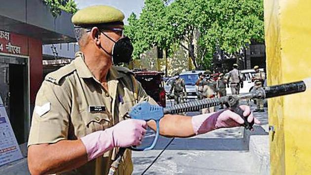 A police officer sprays a disinfectant in Sector 24. A police officer sprays a disinfectant in Sector 24.